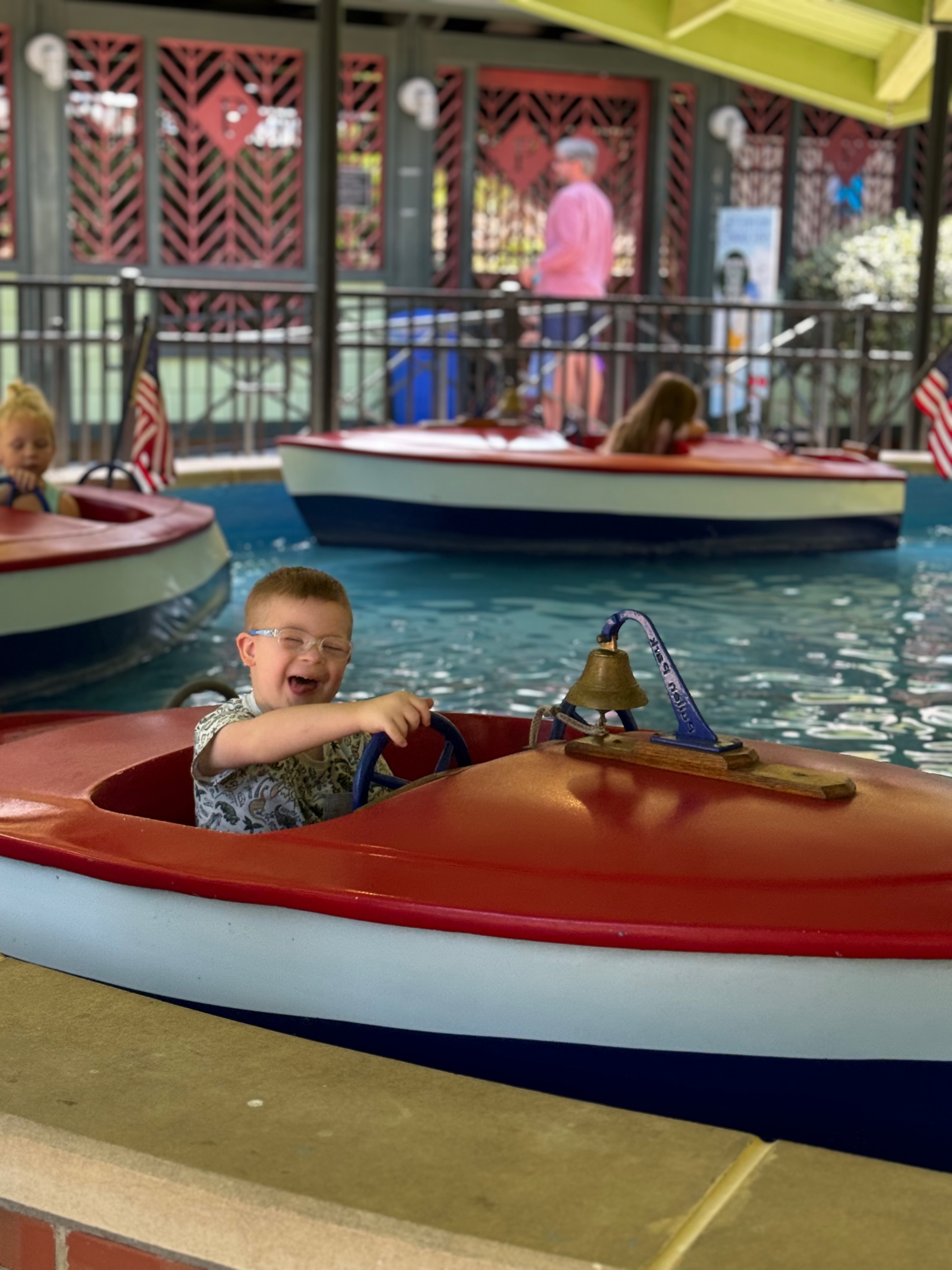 Charlie having a blast on a boat ride at an amusement park