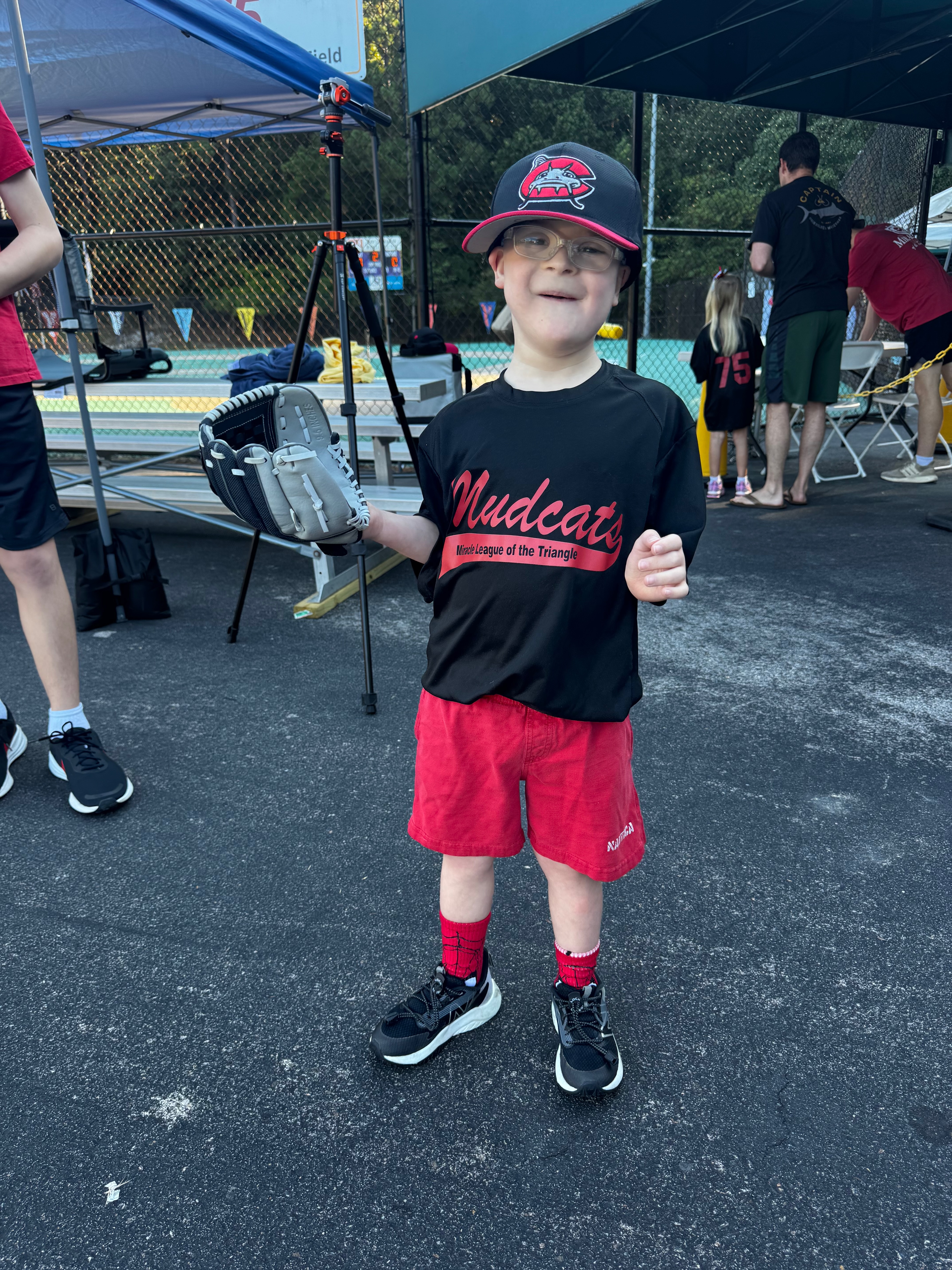 Charlie in his Mudcats Miracle League baseball uniform with a glove